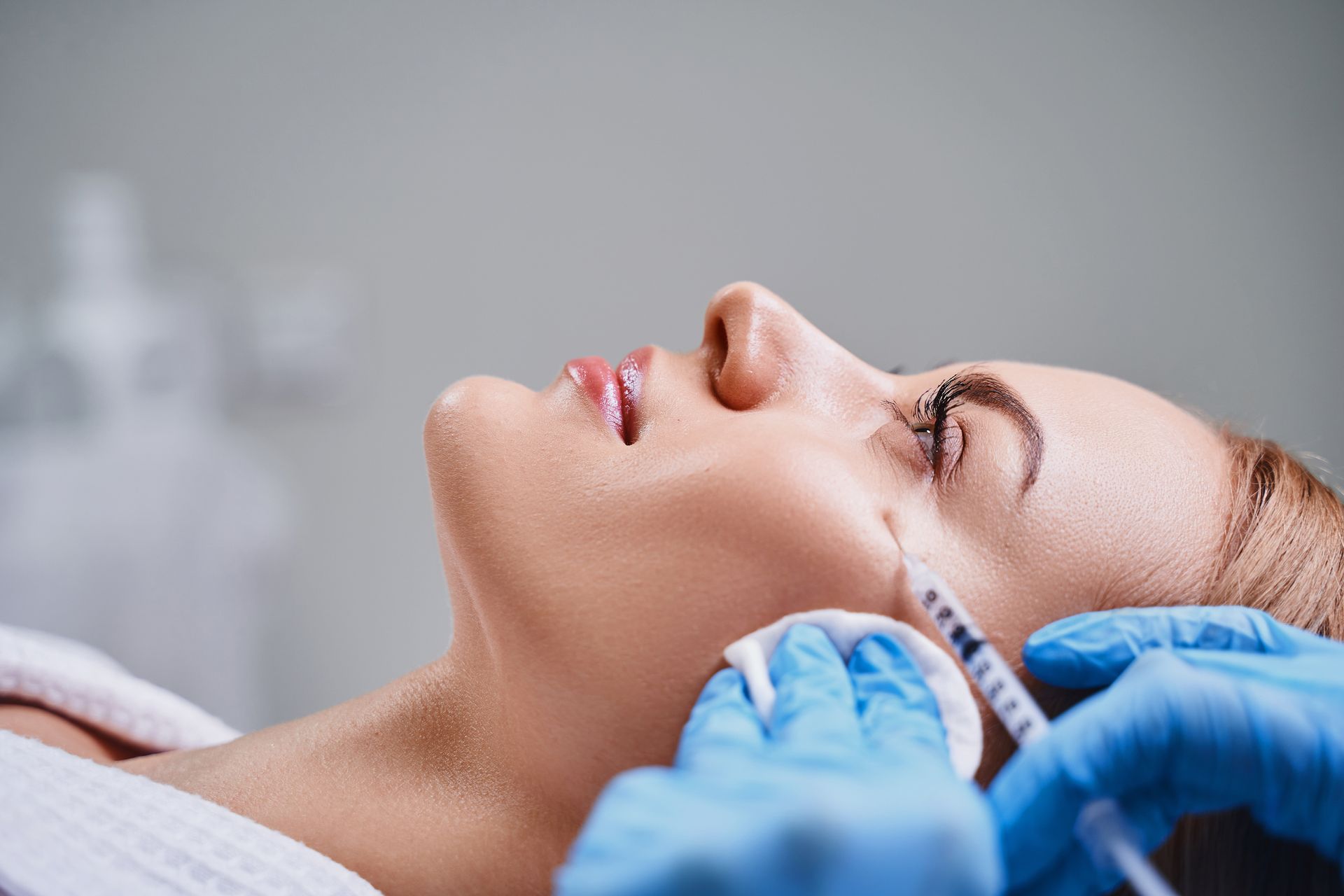 A woman is getting a botox injection in her face.