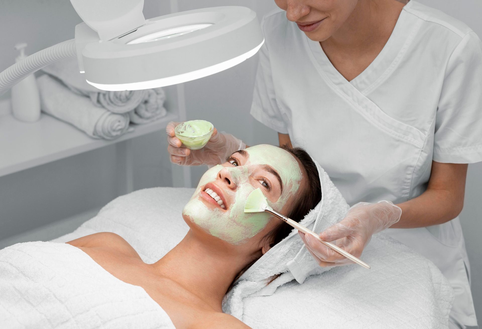 A woman is getting a facial treatment at a beauty salon.