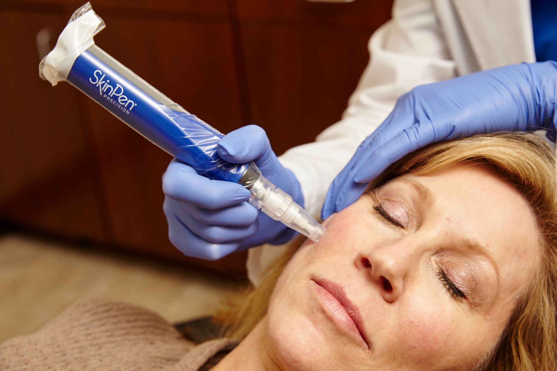 A woman is getting a botox injection in her face.