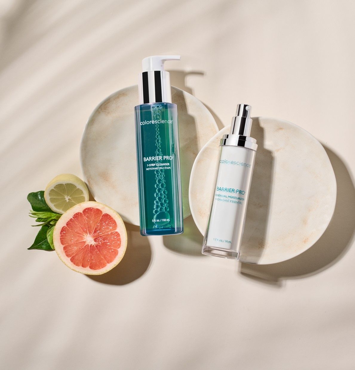 A bottle of lotion next to a grapefruit on a plate