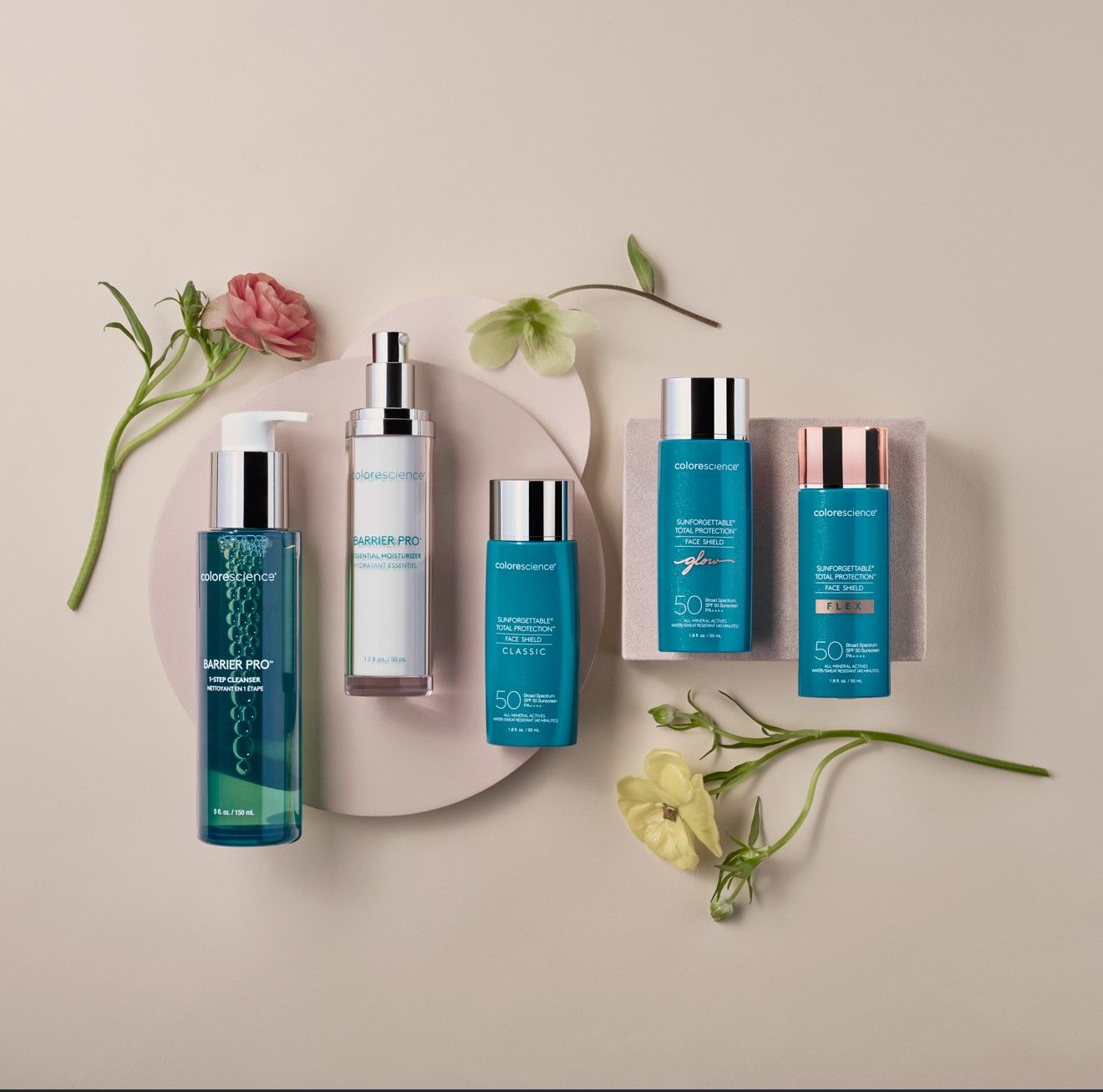 Several bottles of cosmetics are on a table with flowers