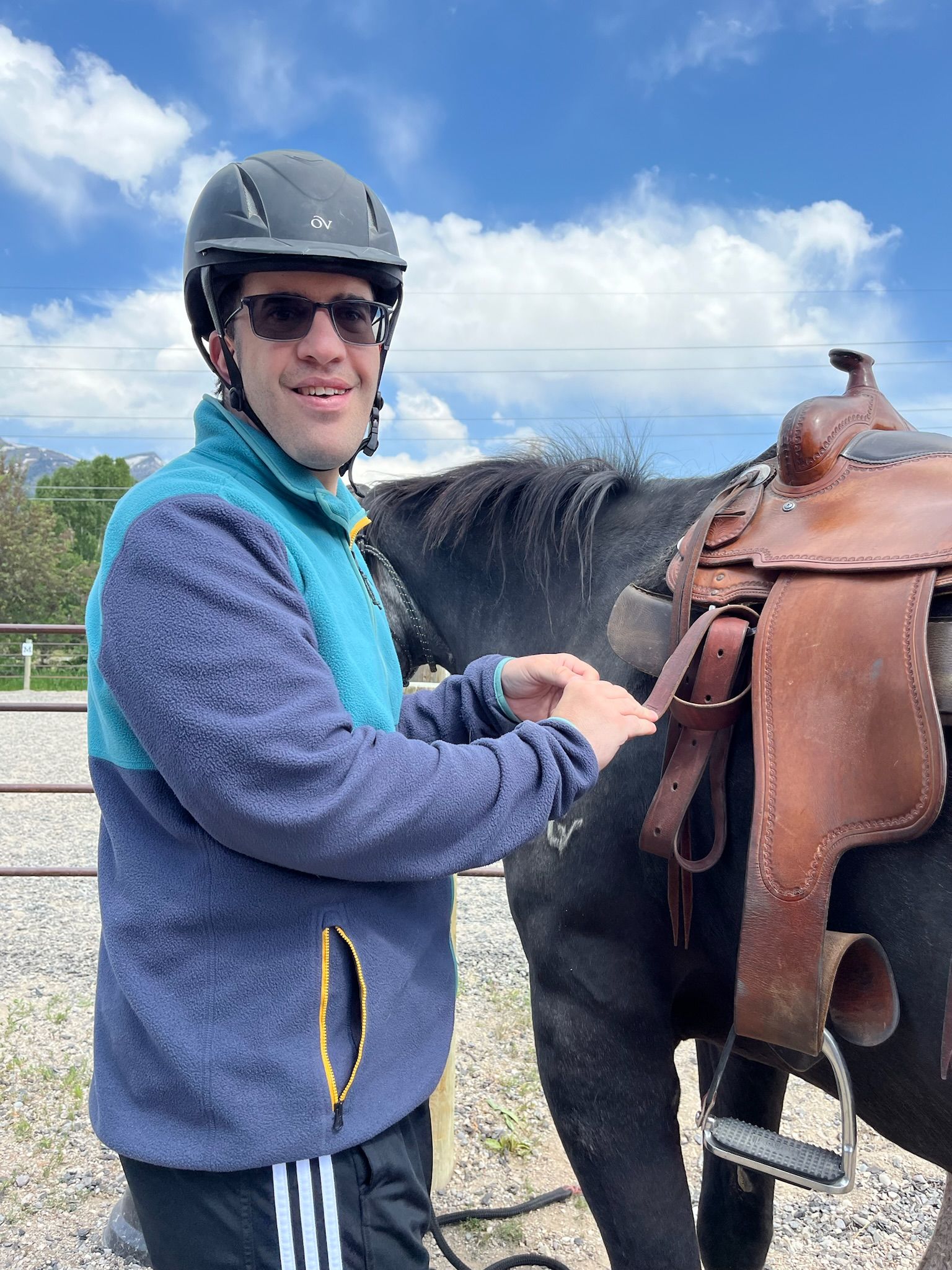 Pony grazing in a wooden pen, light brown and cream coat, tan mane, outdoors.