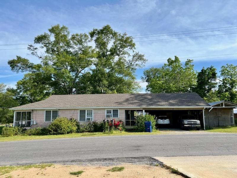 A house with two cars parked in front of it