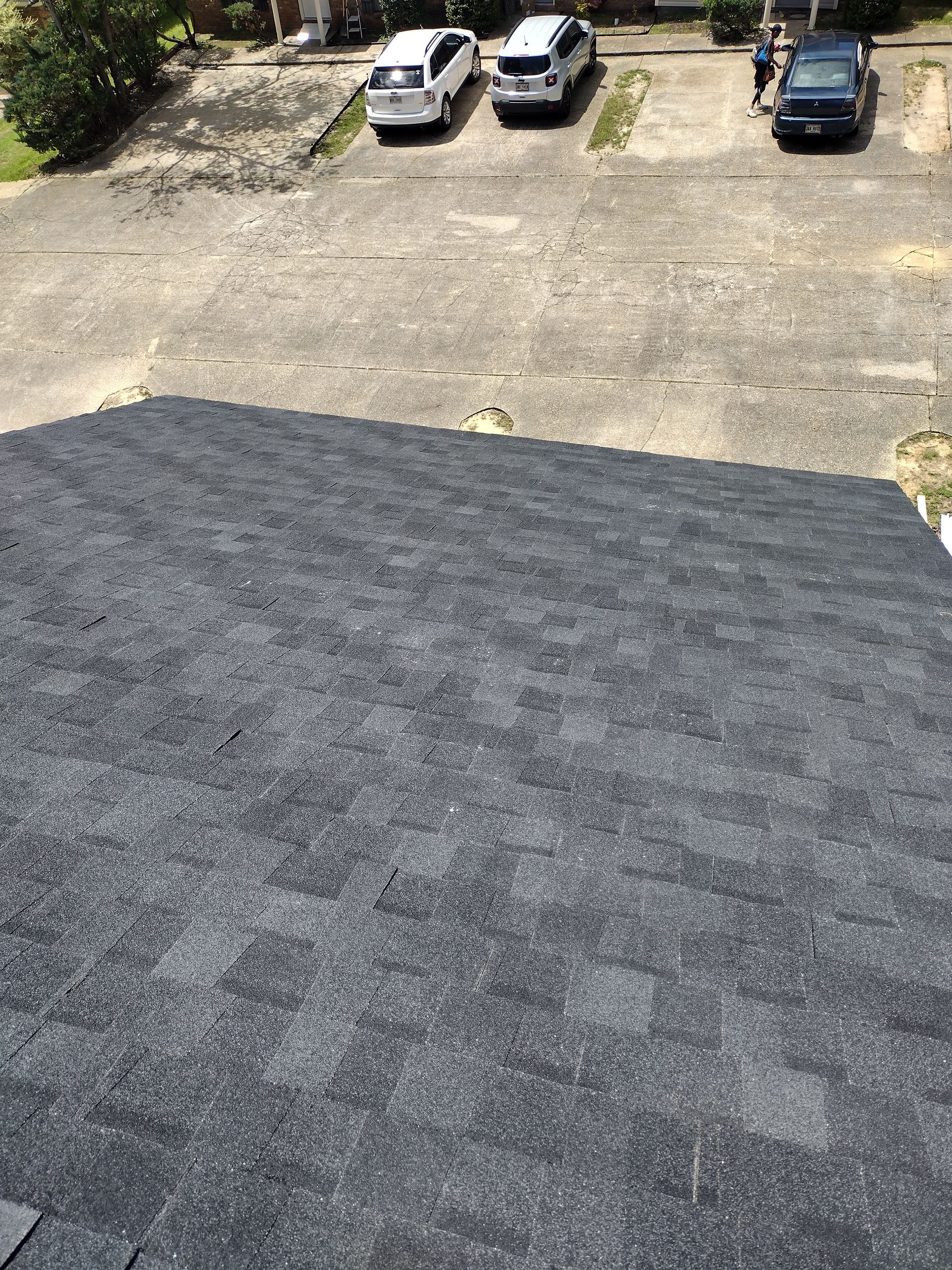 A roof with a lot of shingles and cars parked on it.