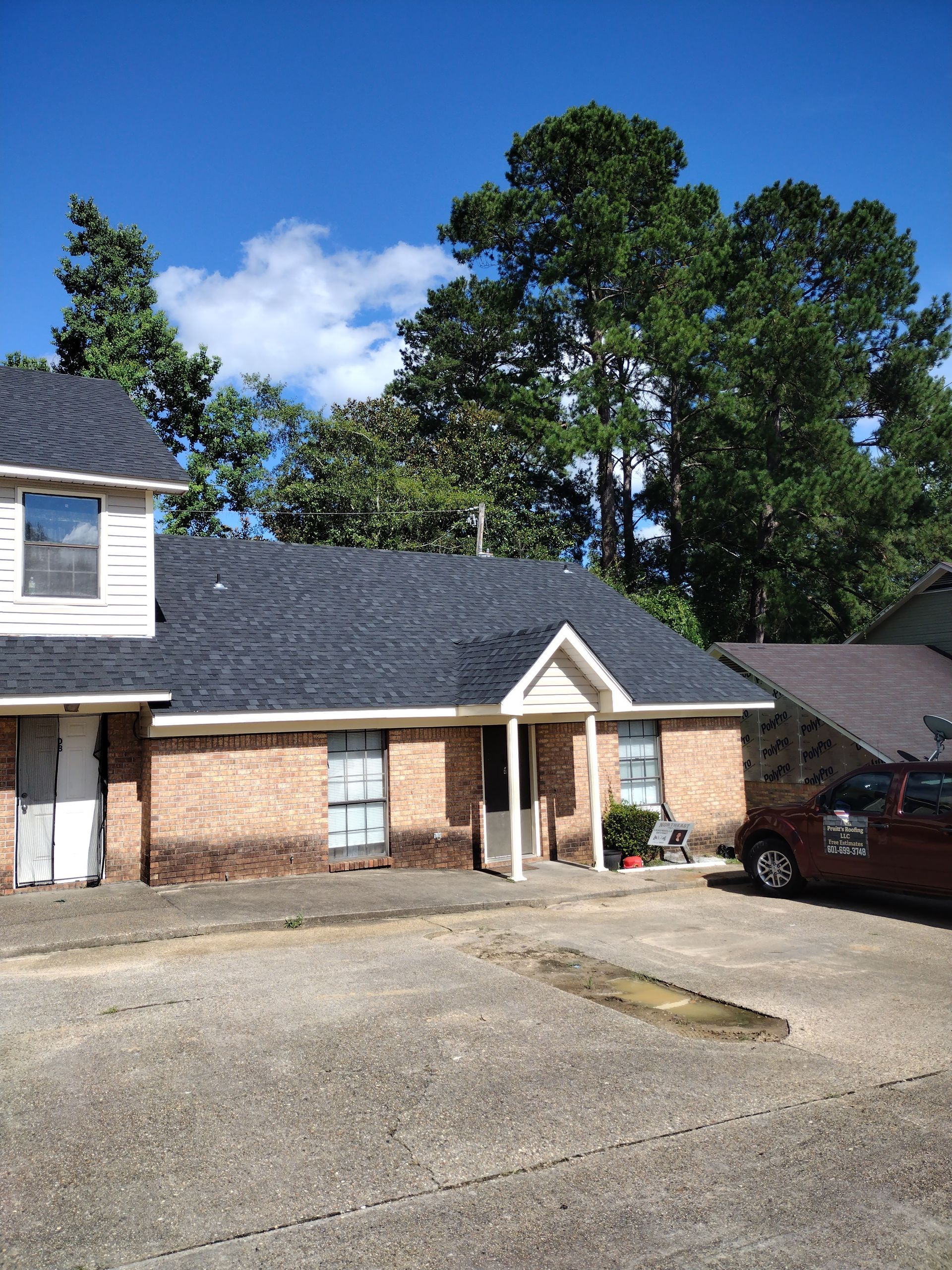 A brick house with a car parked in front of it