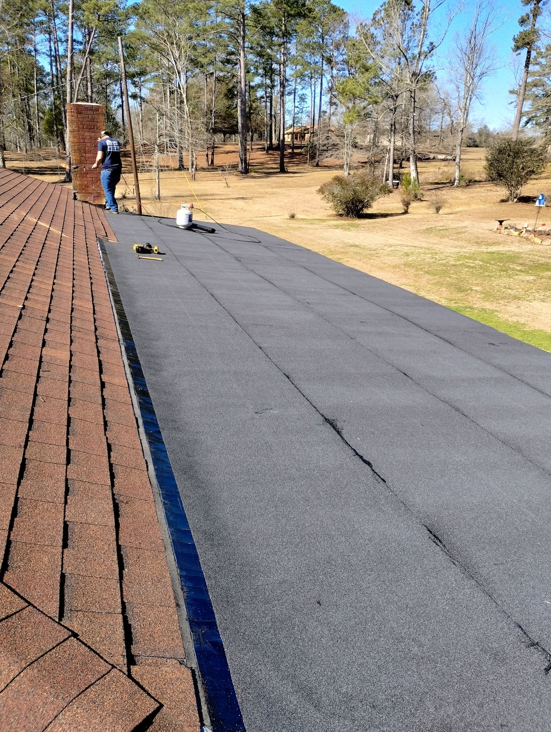 A man is standing on the roof of a house.