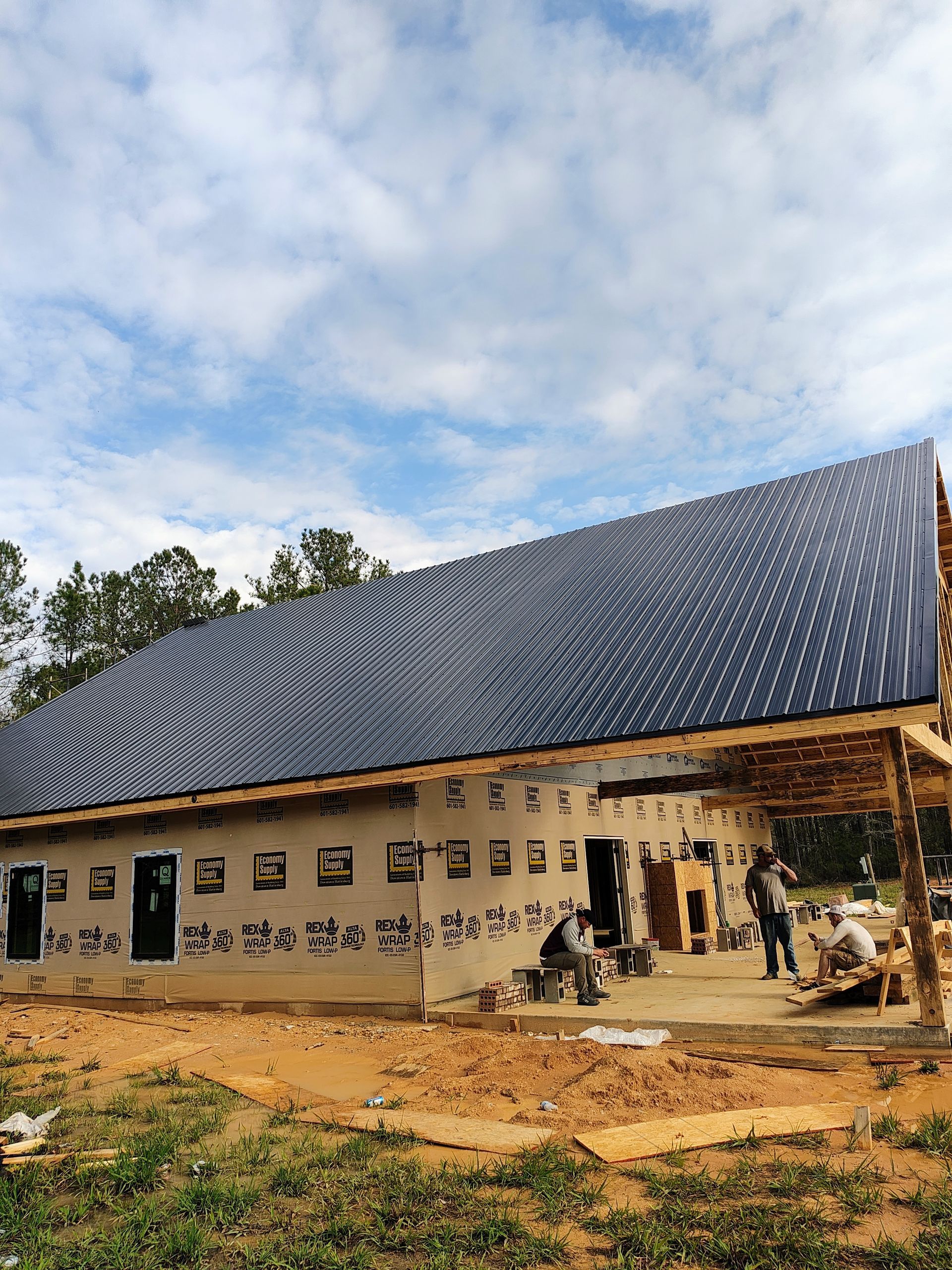A house is being built with solar panels on the roof.
