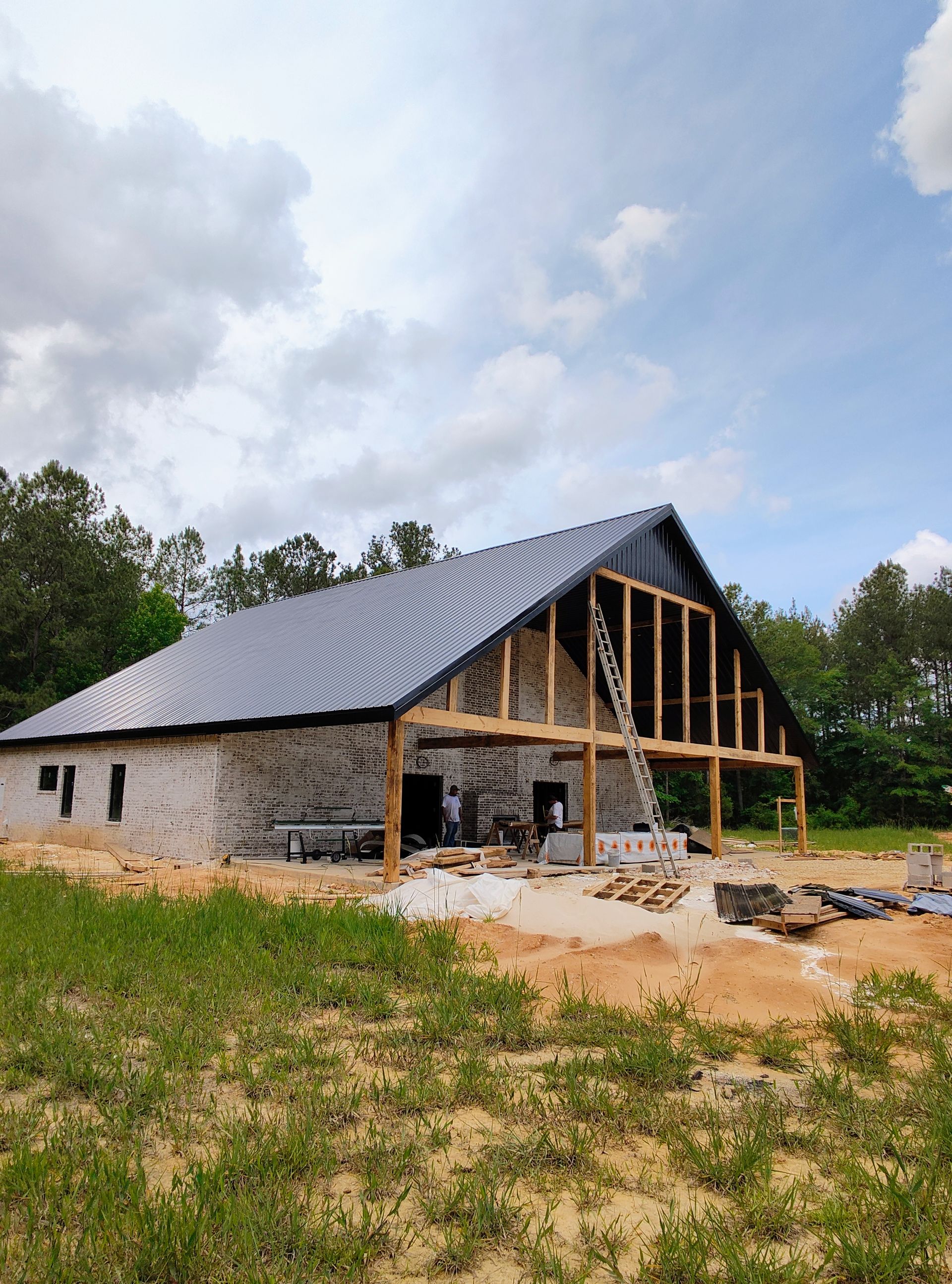 A large barn is being built in the middle of a field.