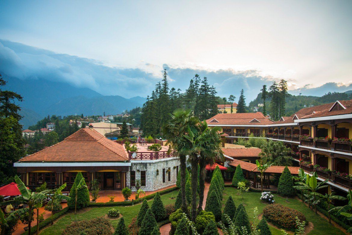 An aerial view of a hotel with mountains in the background.