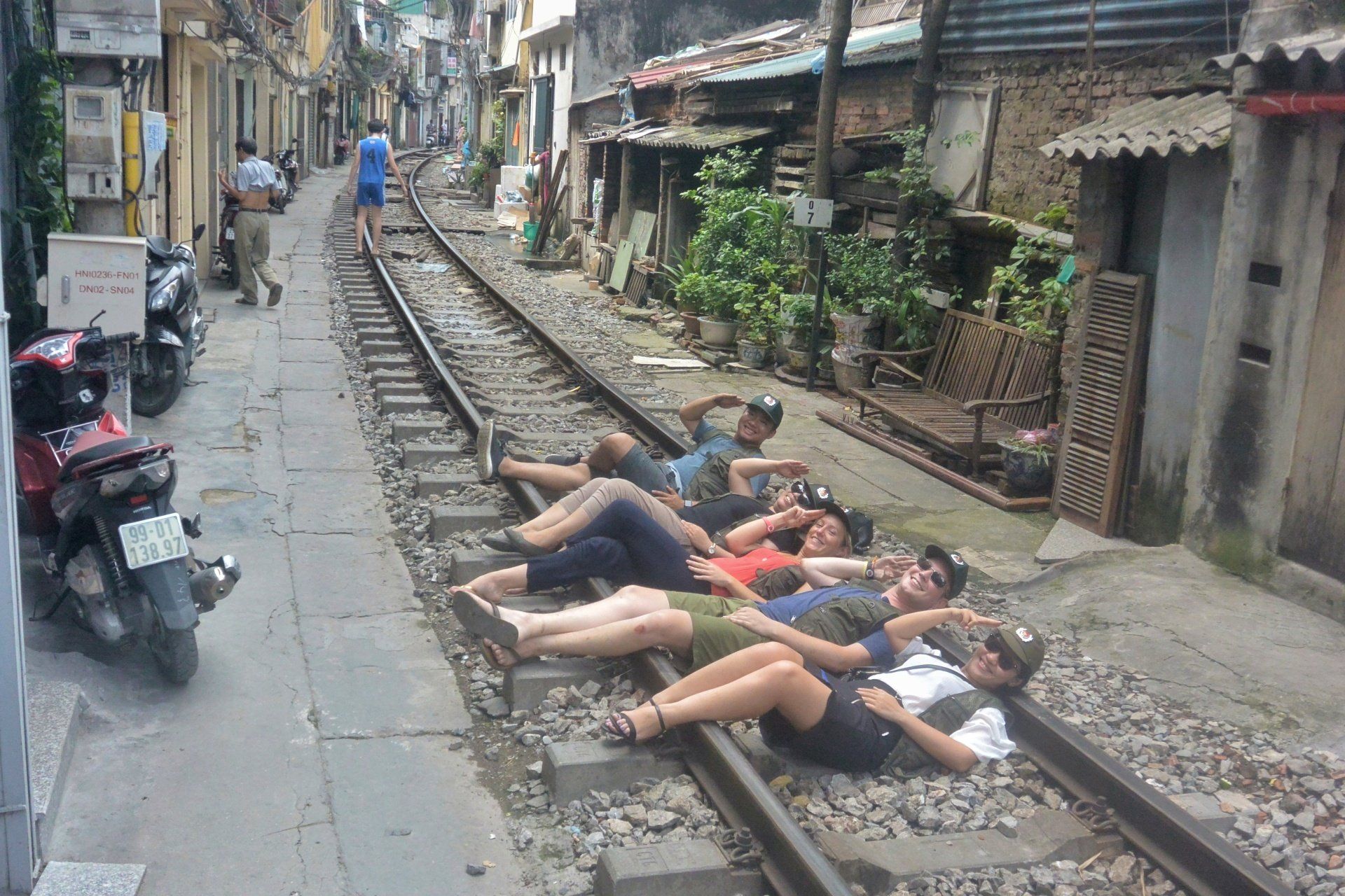 A group of people are laying on train tracks