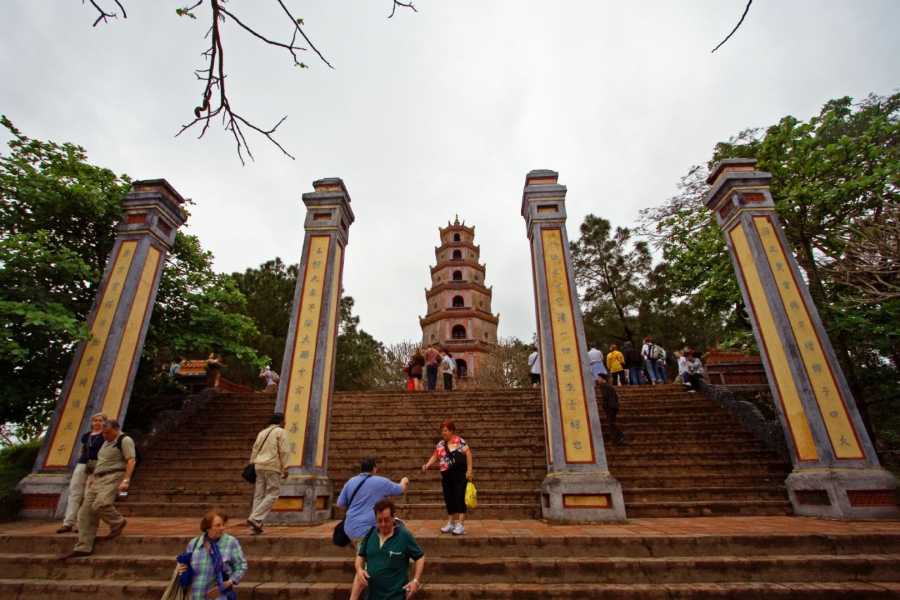 A group of people are walking up a set of stairs towards a tower.
