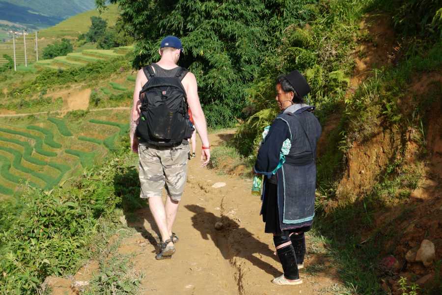 A man and a woman are walking down a dirt path.