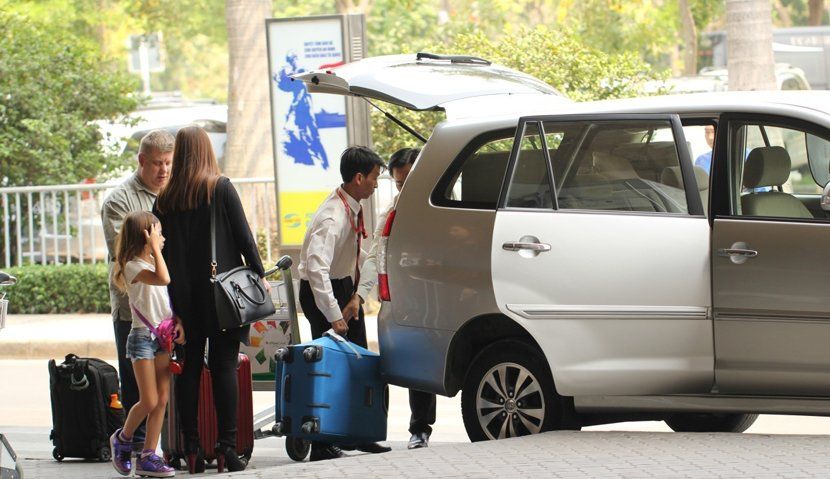 A group of people are loading luggage into a car.