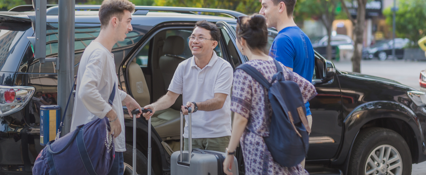 A group of people are getting out of a car with luggage.