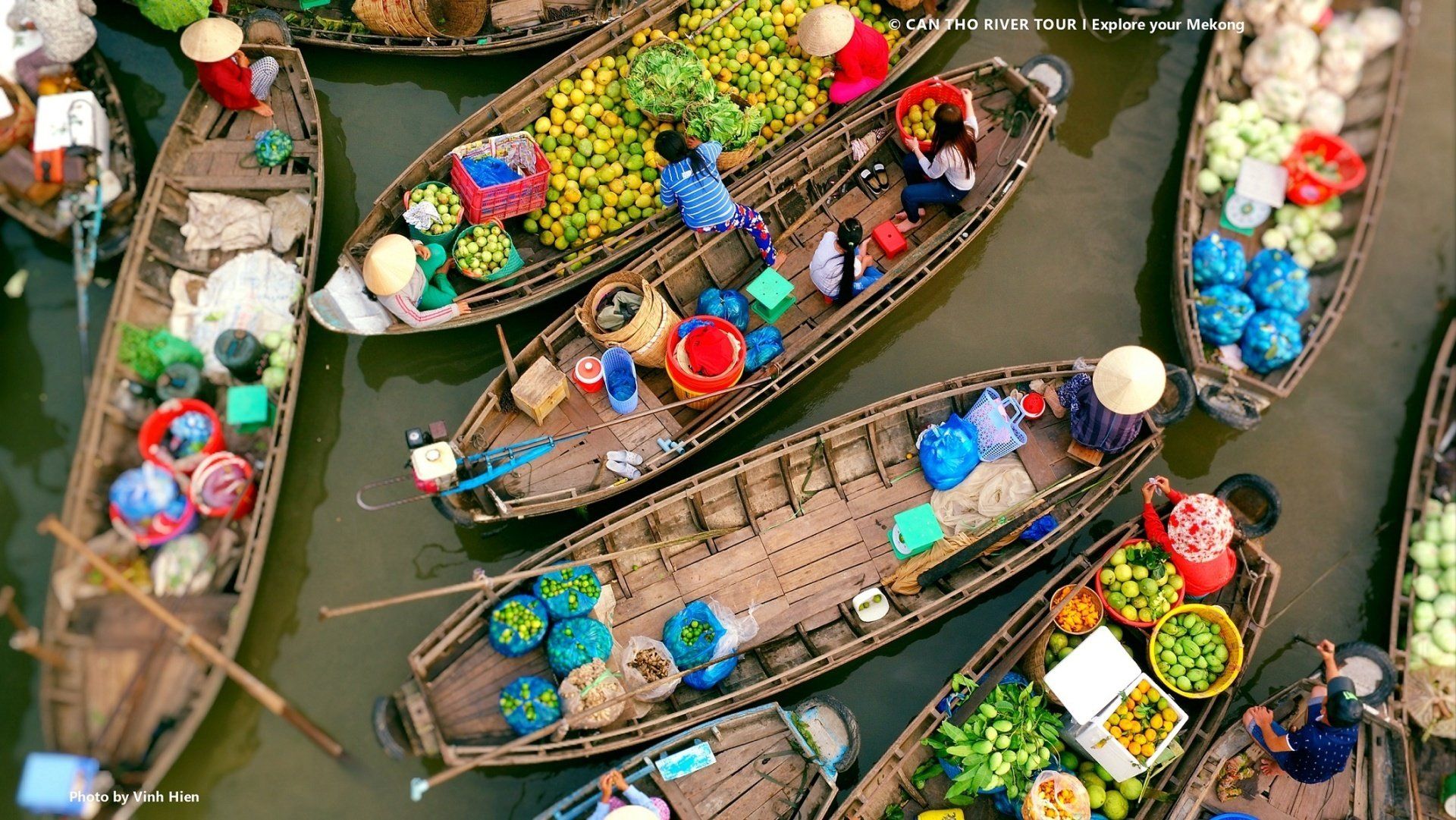 A group of boats filled with fruits and vegetables are floating on top of a body of water.