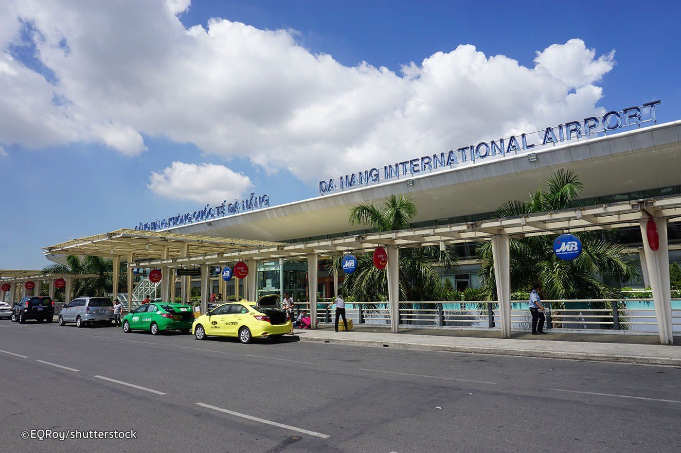 A row of cars are parked in front of a building that says international airport.