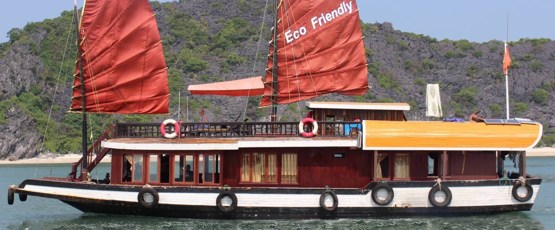 A boat with red sails is floating on the water.
