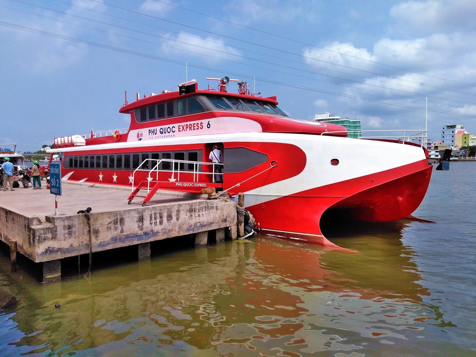 A red and white boat is docked at a dock.