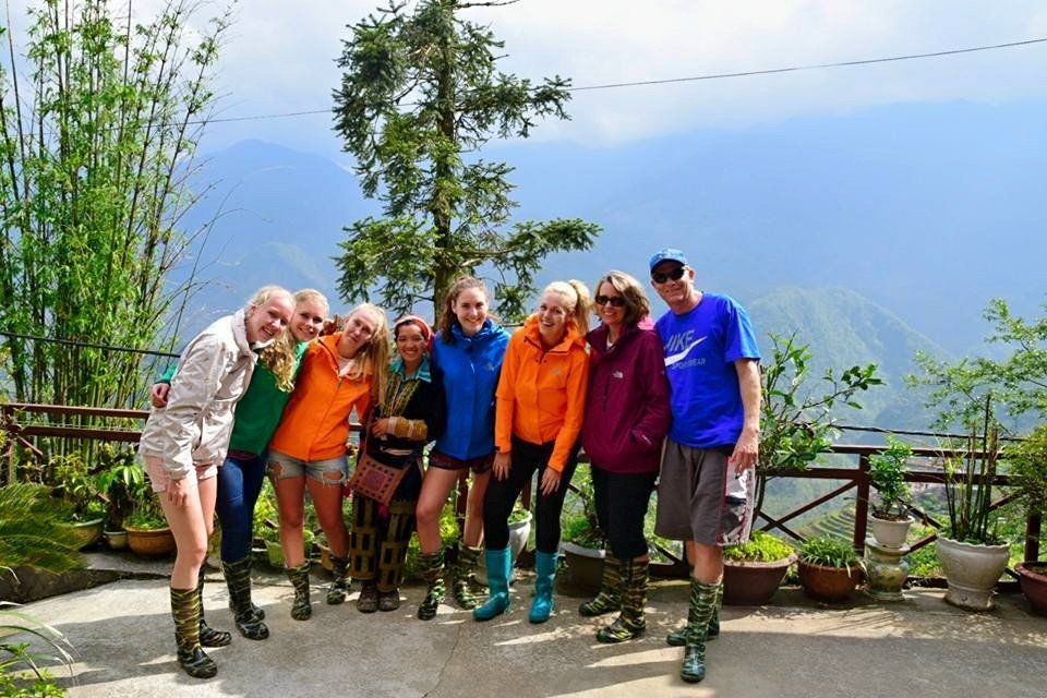 A group of people posing for a picture with mountains in the background.