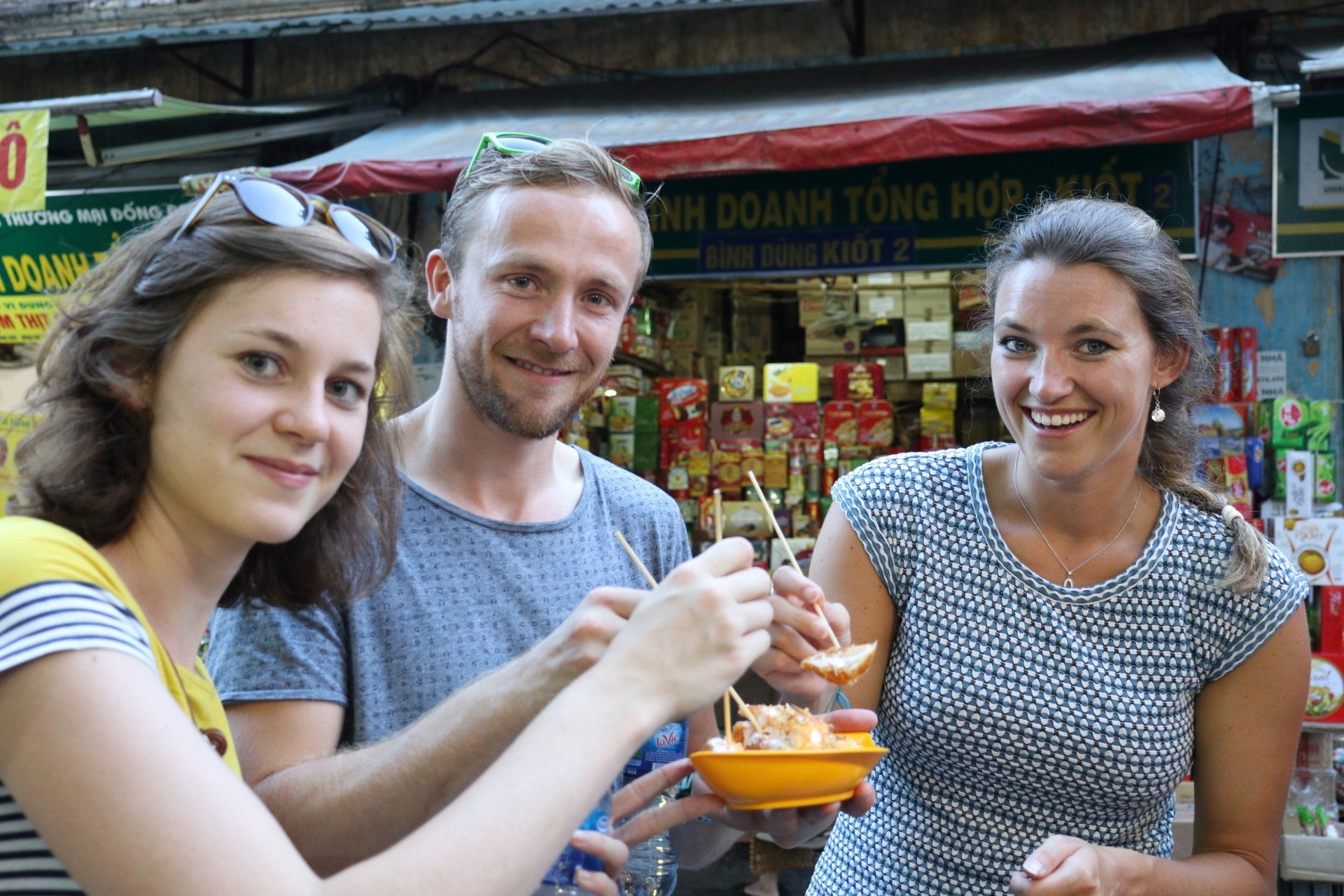 A group of people are standing next to each other eating food.