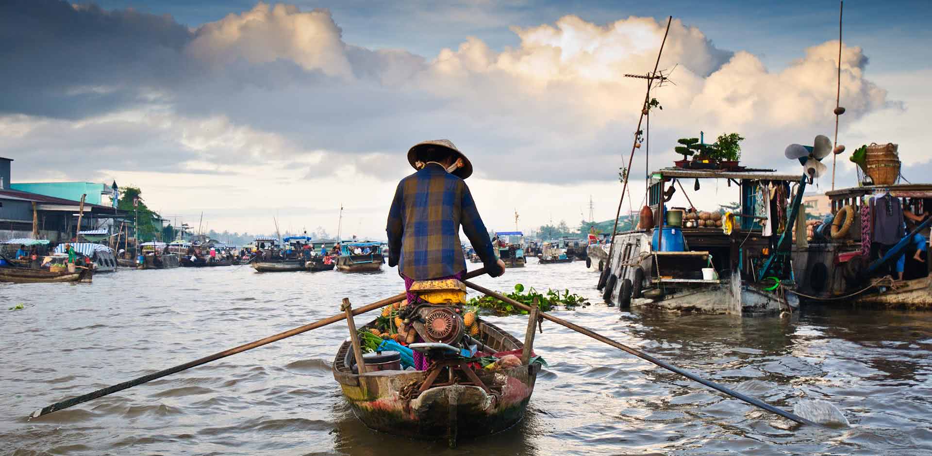 A woman is rowing a boat on a river.