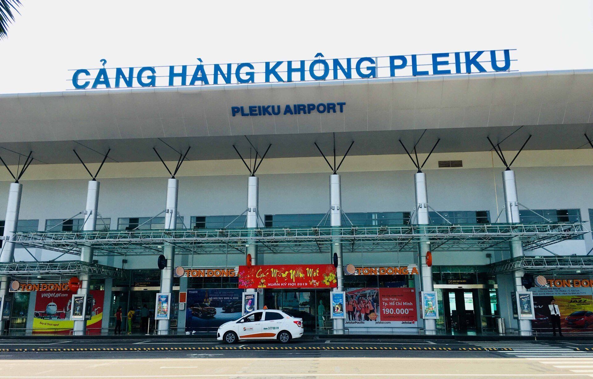 A white car is parked in front of the pleiku airport
