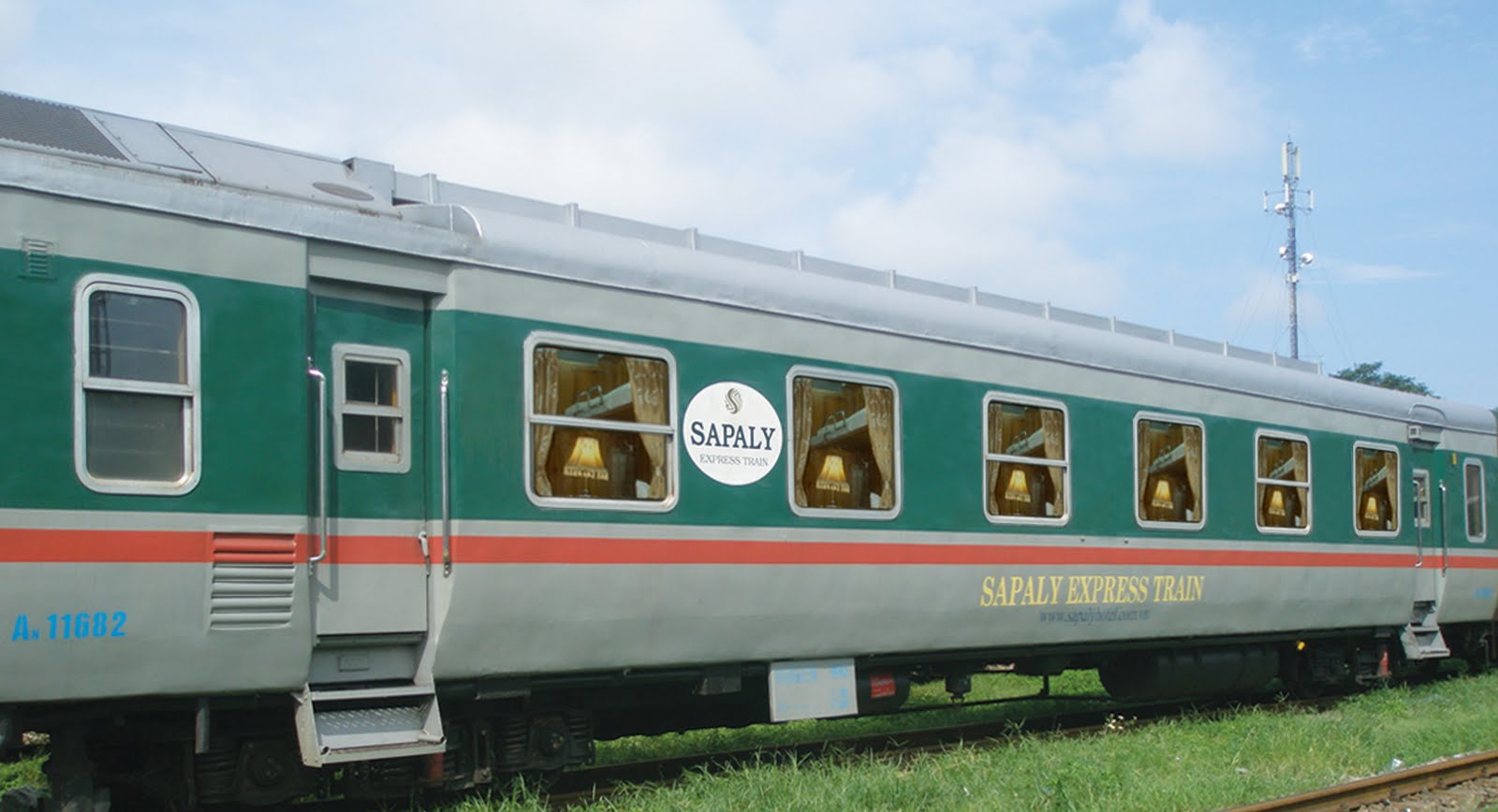 A green and gray train is parked on the tracks