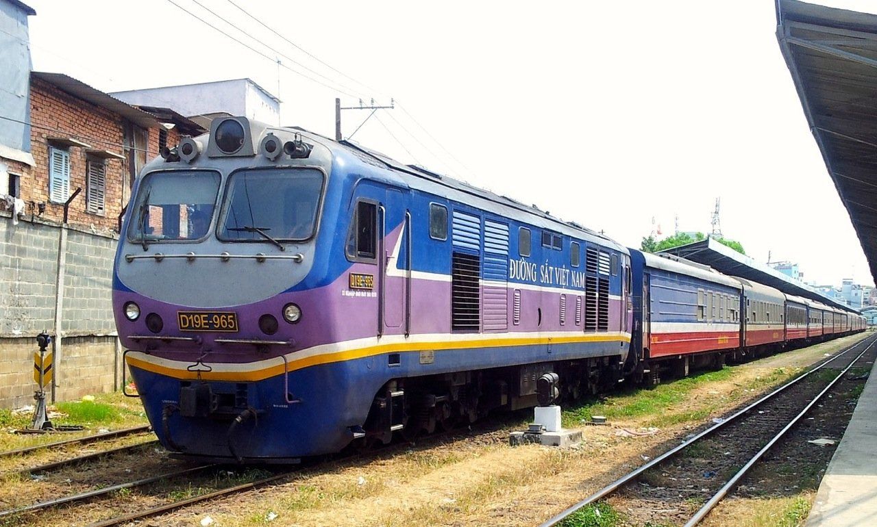 A blue and purple train is parked on the tracks.
