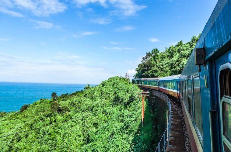 A train is going over a bridge overlooking the ocean.