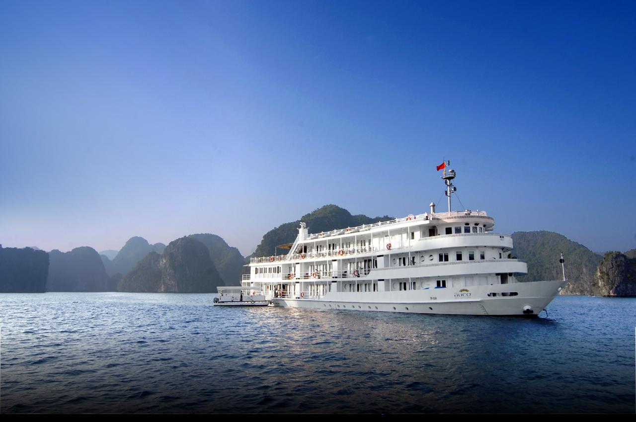 A large white cruise ship is floating on top of a body of water.