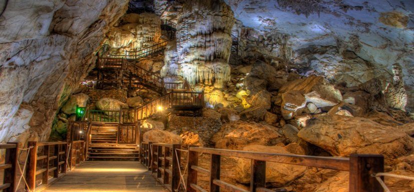 There is a wooden walkway in the middle of a cave.