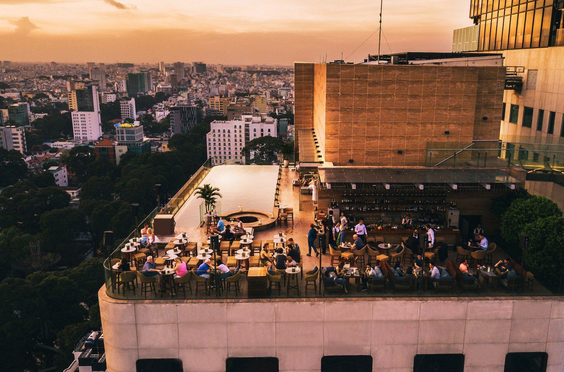 A group of people are sitting at tables on the roof of a building.