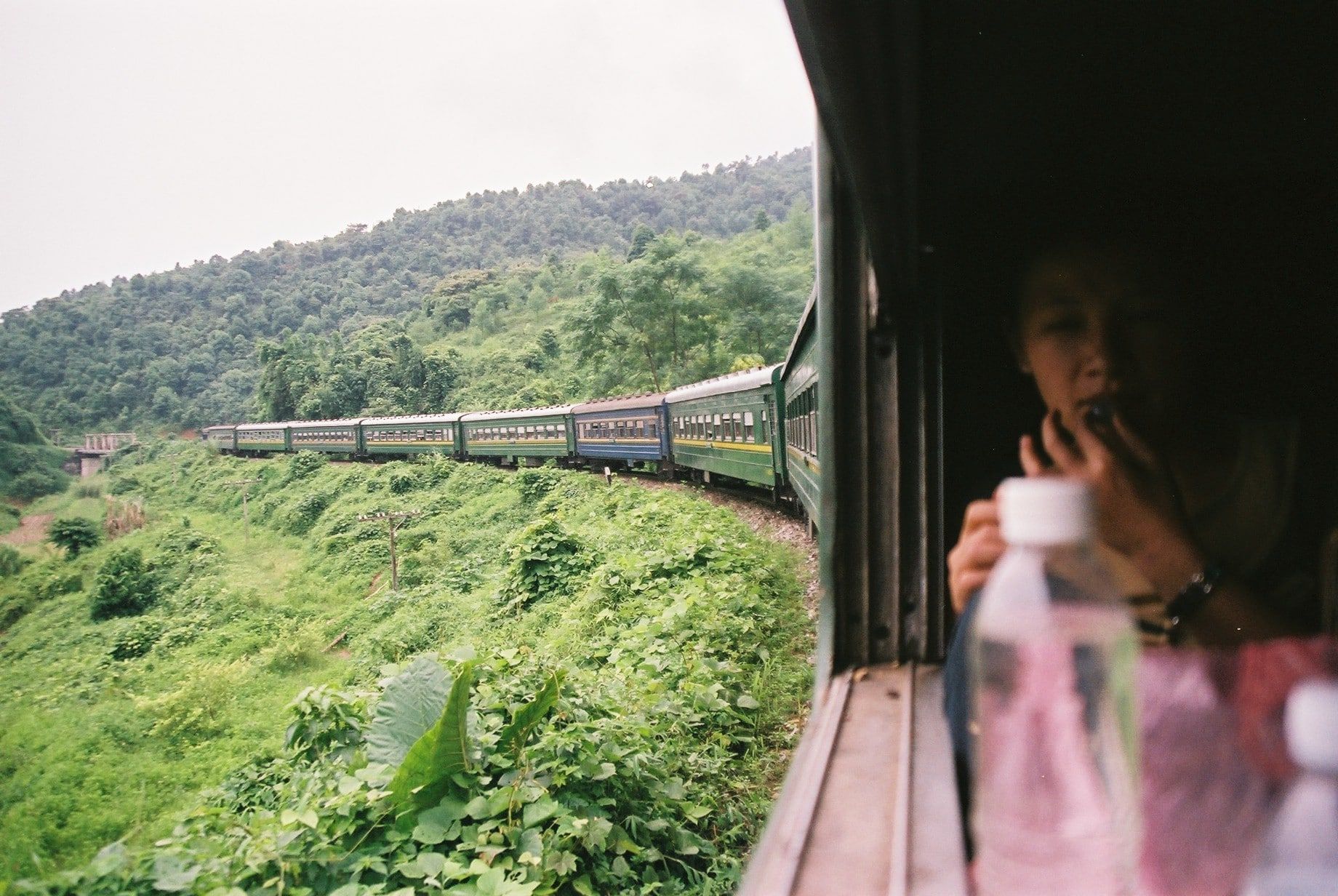A woman is looking out of the window of a train.
