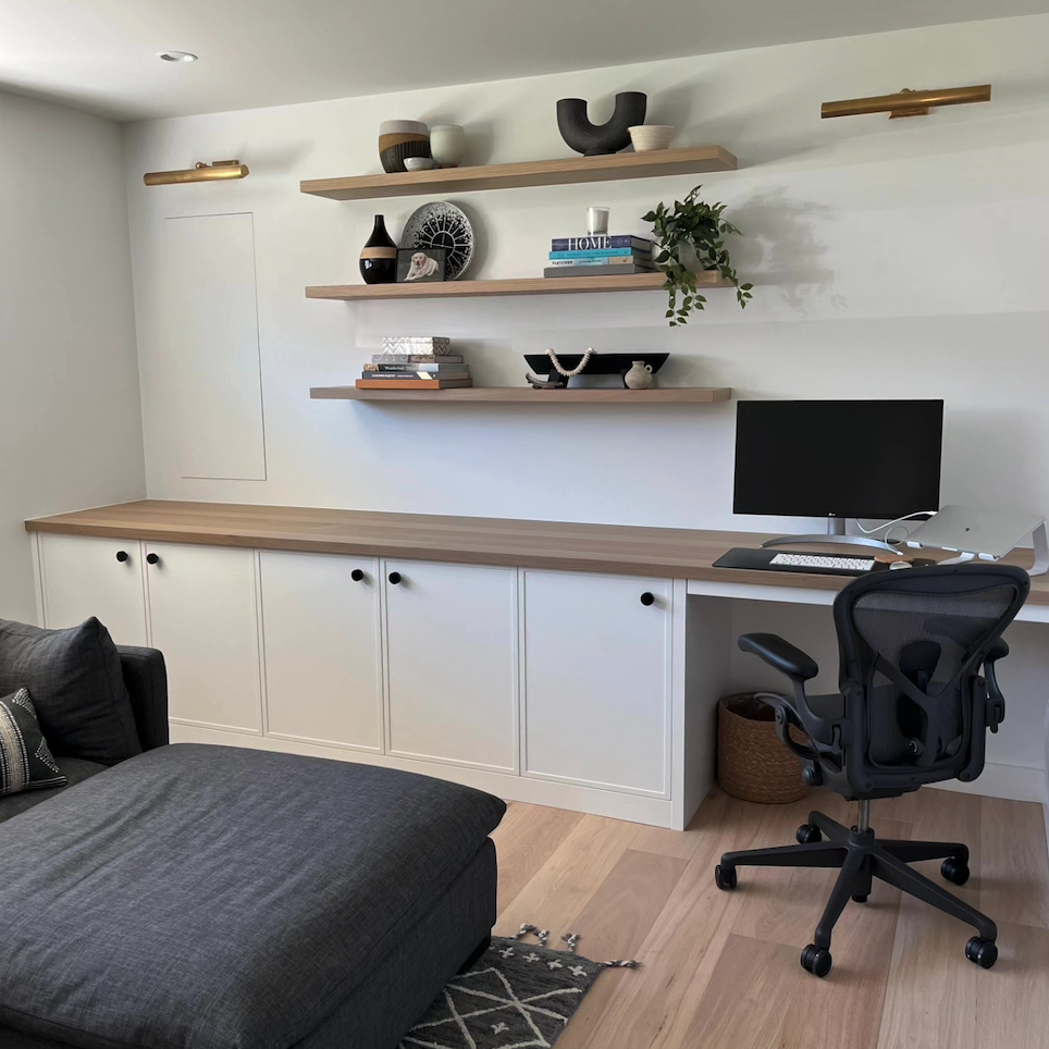 A living room with a couch a desk and a computer