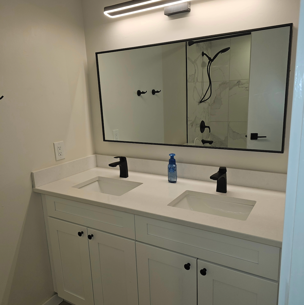 A bathroom with two sinks and a large mirror
