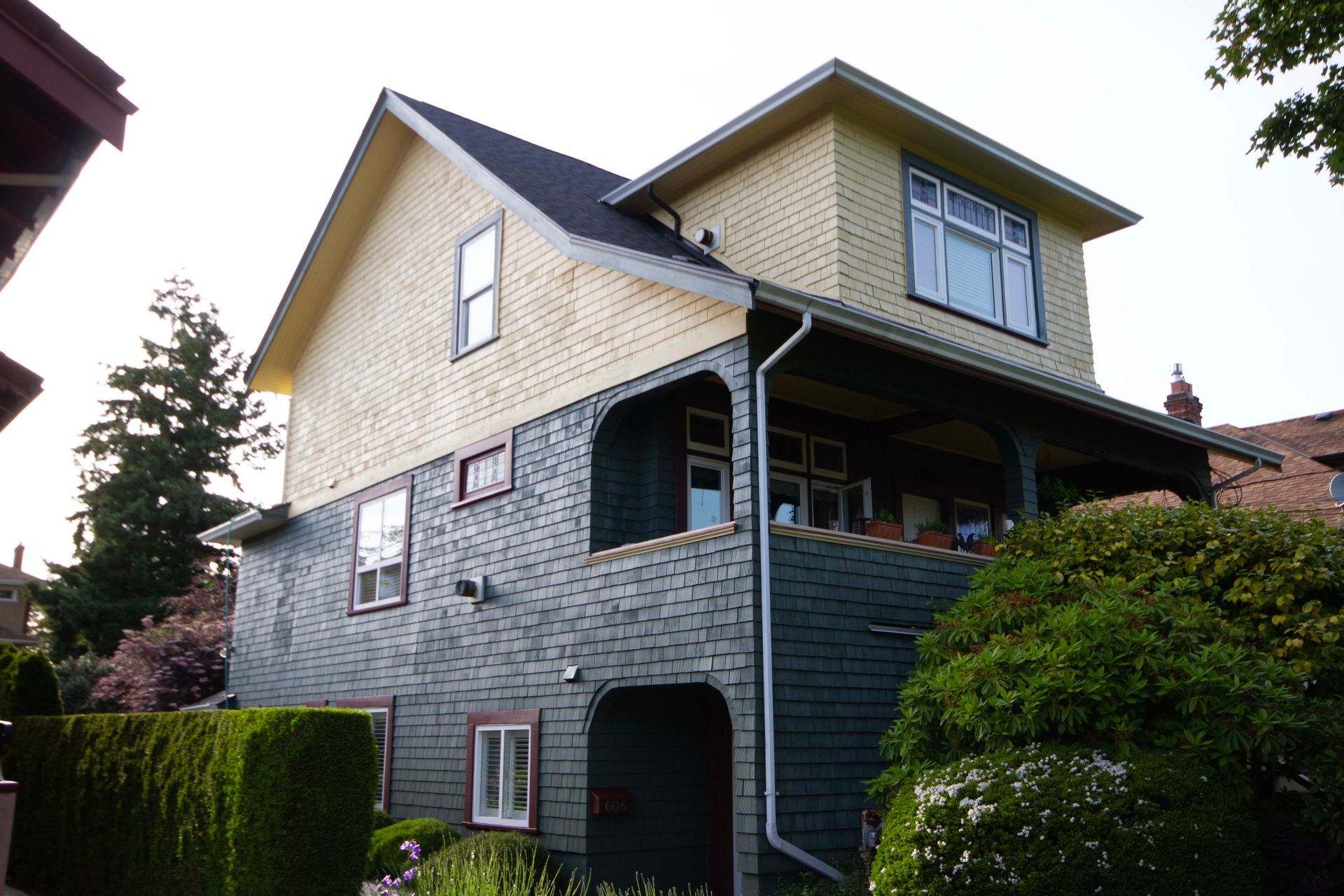 A house with a yellow siding and a black roof