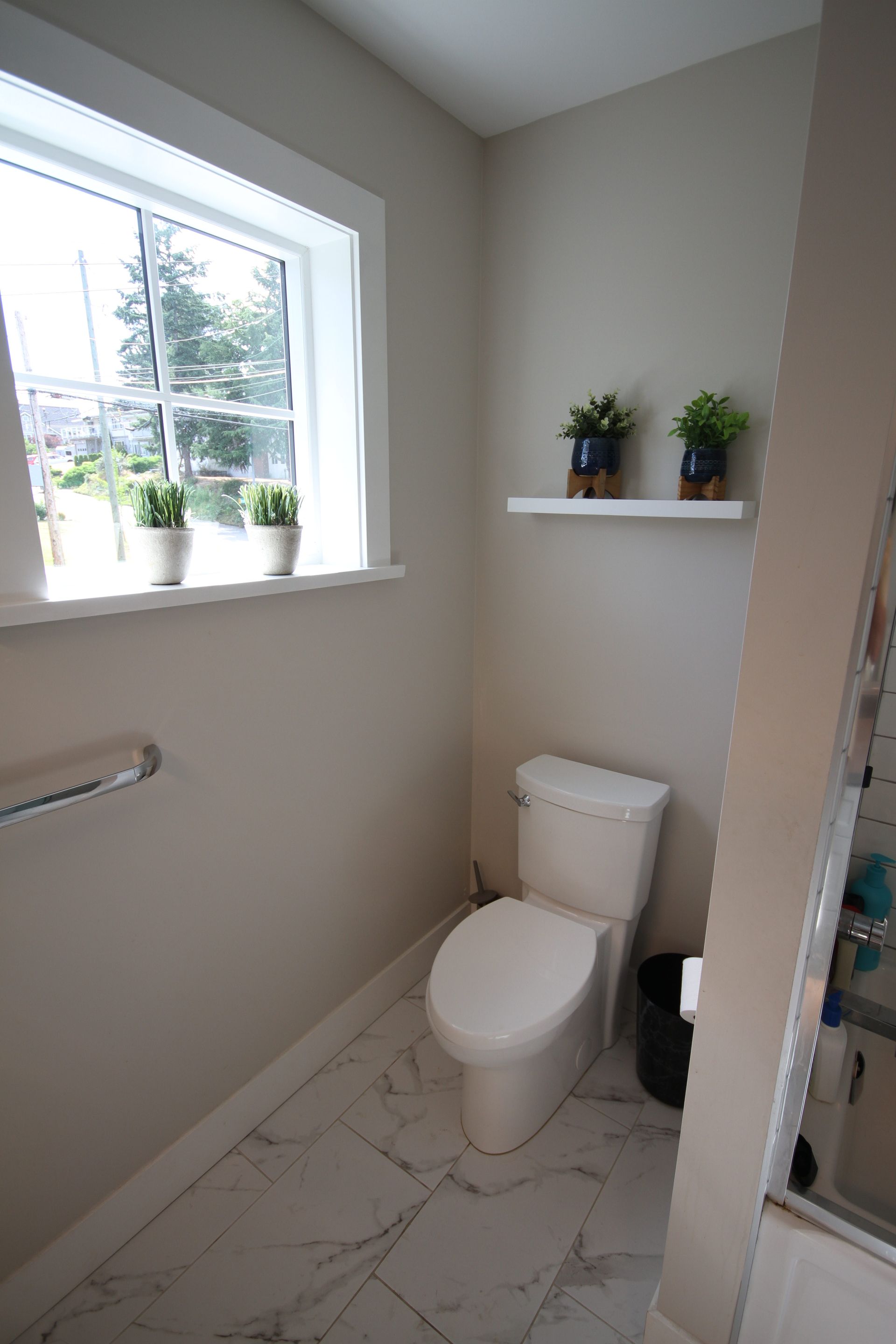A bathroom with a toilet and a window.