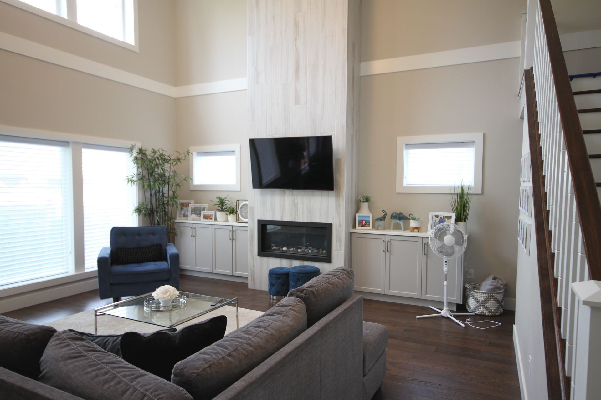 A living room with a couch , chair , television and fireplace.