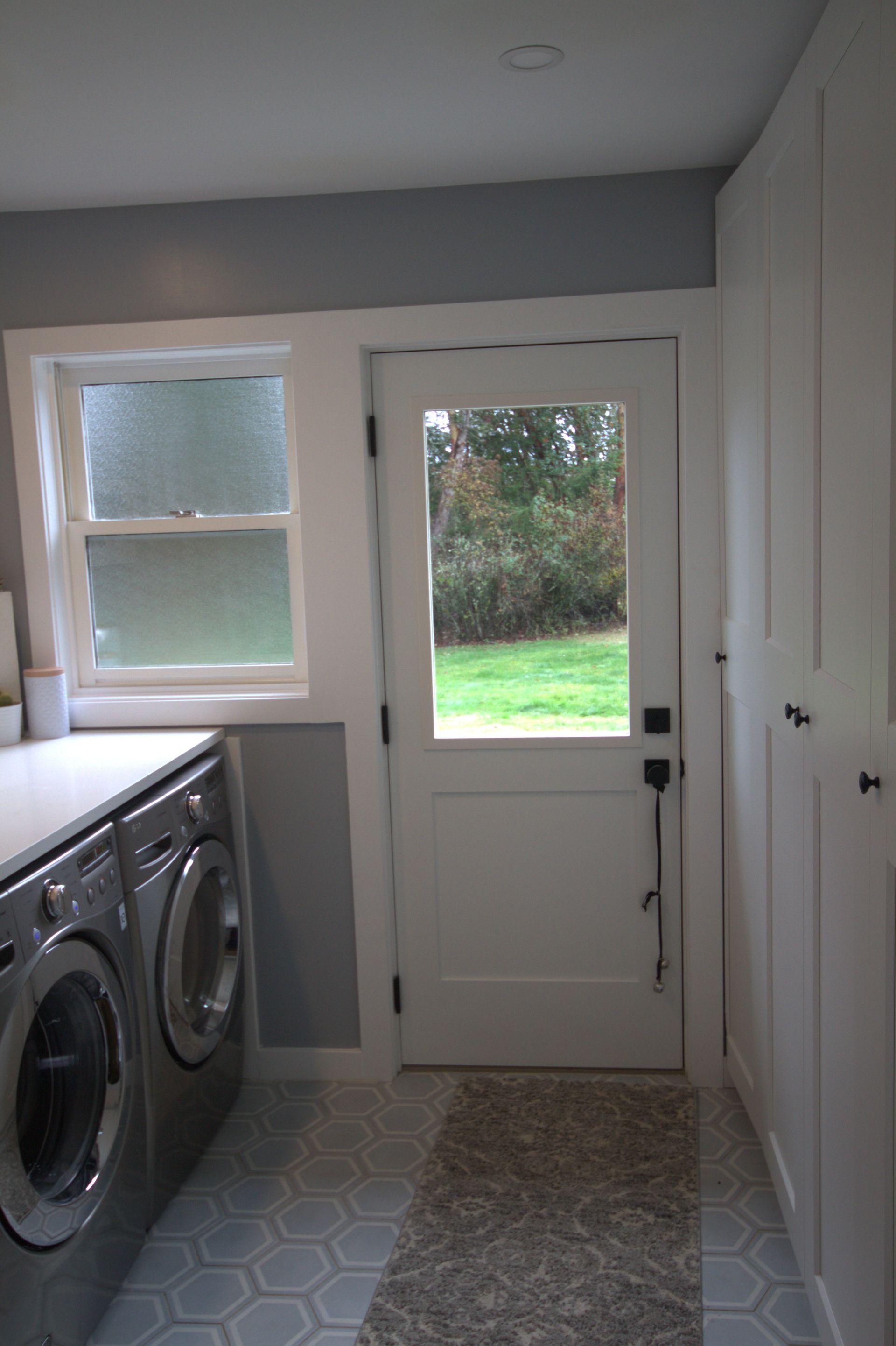 A laundry room with a washer and dryer and a window