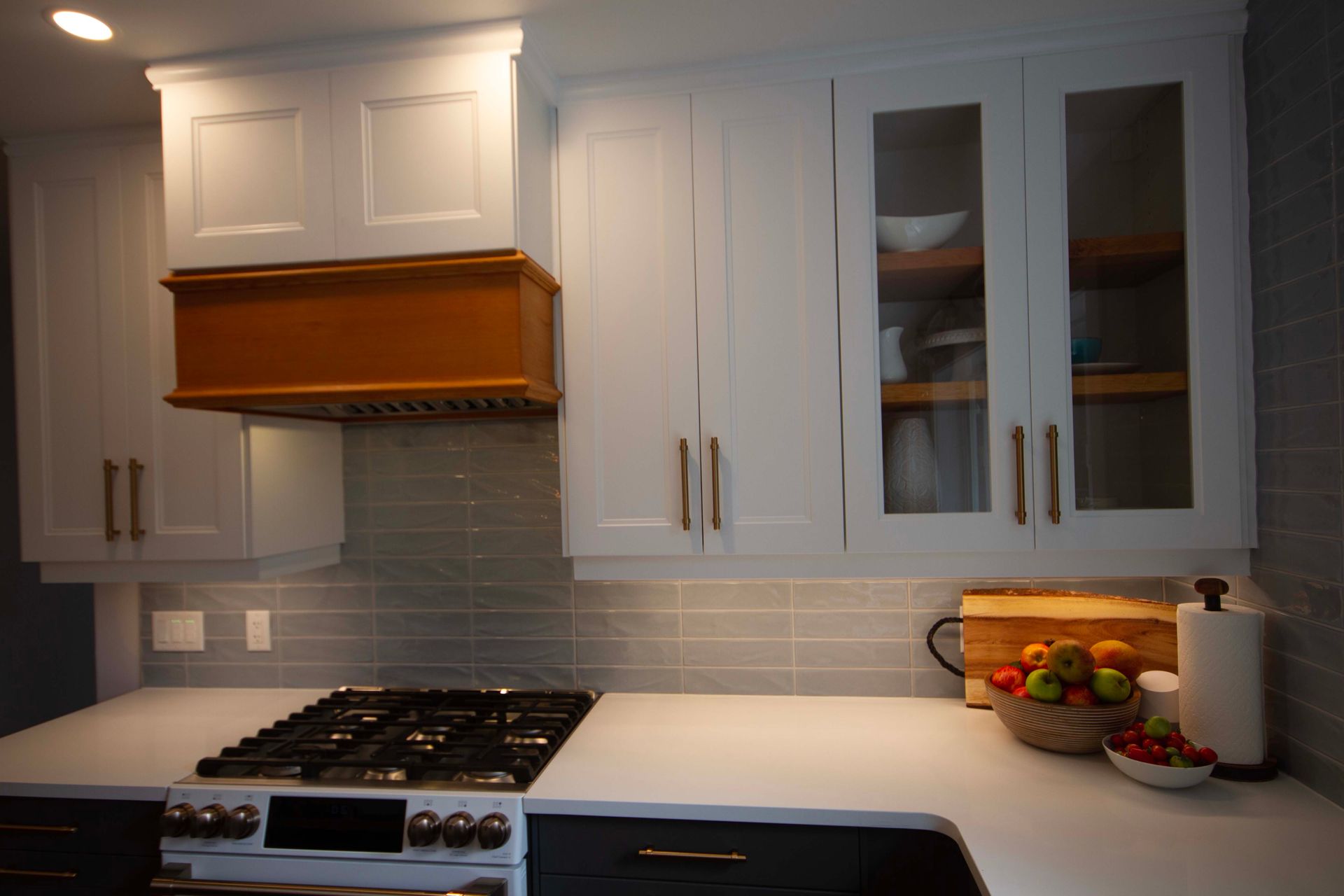 A kitchen with white cabinets and a stove top oven.