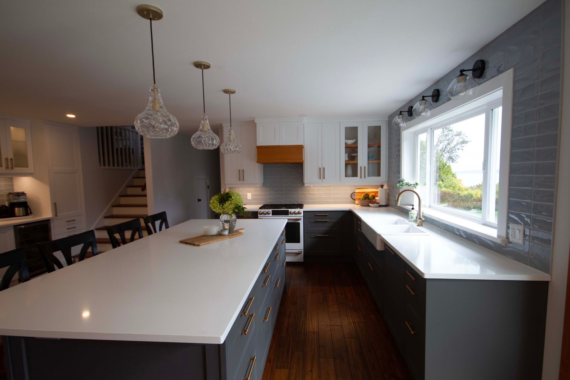 A kitchen with a large island and white counter tops.