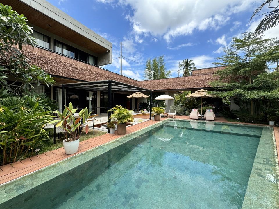 An aerial view of a modern house with a large swimming pool.