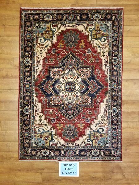 Red, navy, and cream oriental rug on a wood floor.