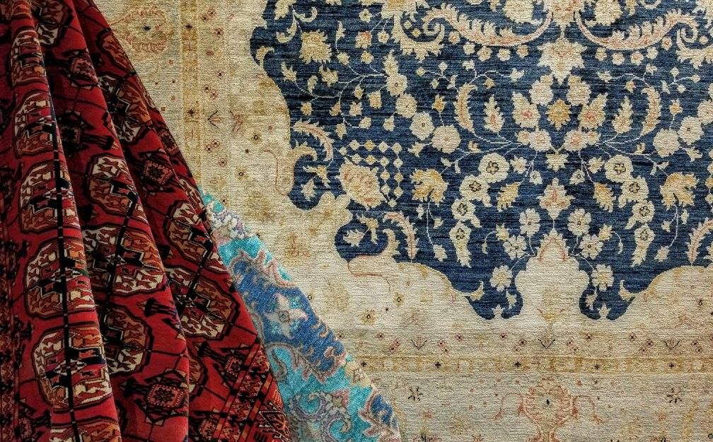 Red patterned textile with blue and beige rug, featuring floral design.