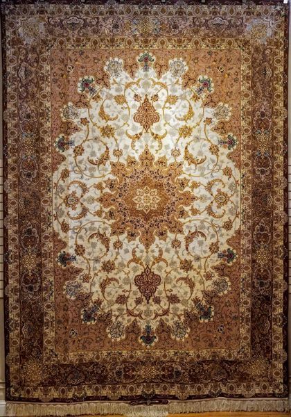 Ornate Persian rug with cream and brown floral patterns.