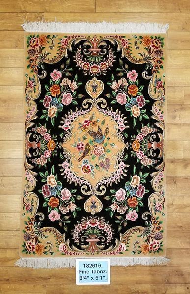 Oriental rug with floral and bird motifs, black background, cream border.