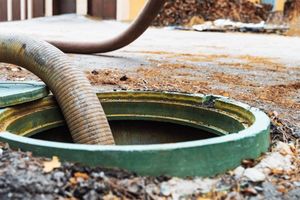 A hose is being pumped into a septic tank.