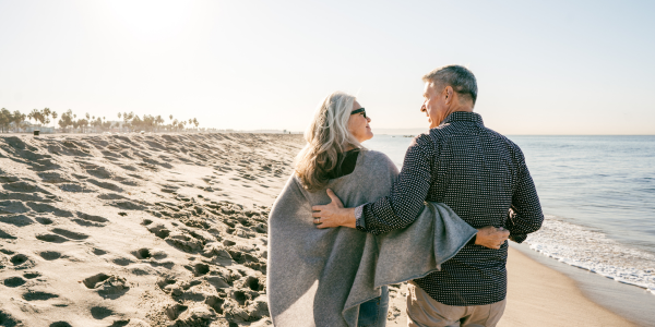 couple walking on beach discussing funeral plans