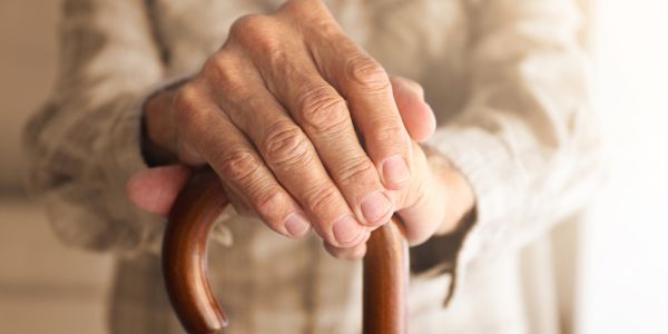 elderly man with final expense insurance holding cane