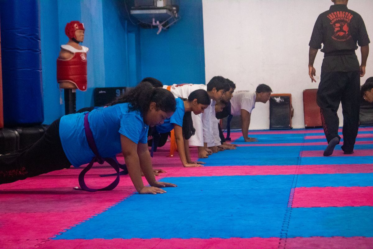 Partners drill technique at Universal Mixed Martial Arts in South Richmond Hill, NY, building teamwork and fitness.